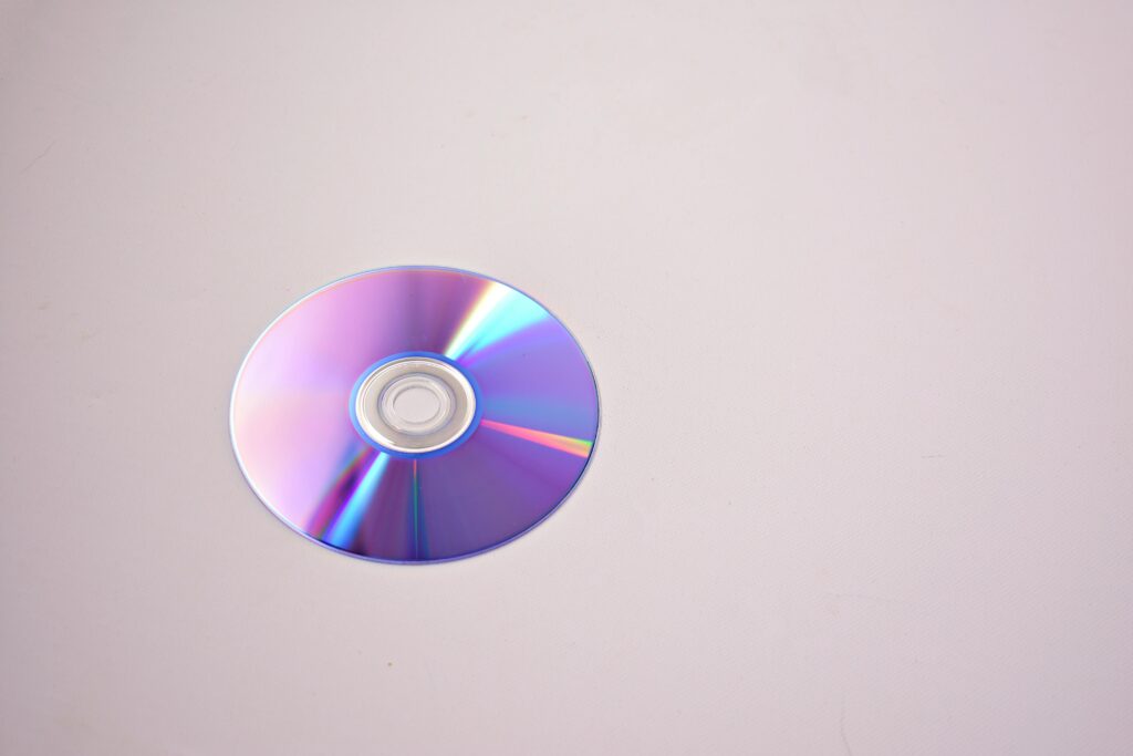Captivating photo of a colorful CD on a minimalistic pastel backdrop.